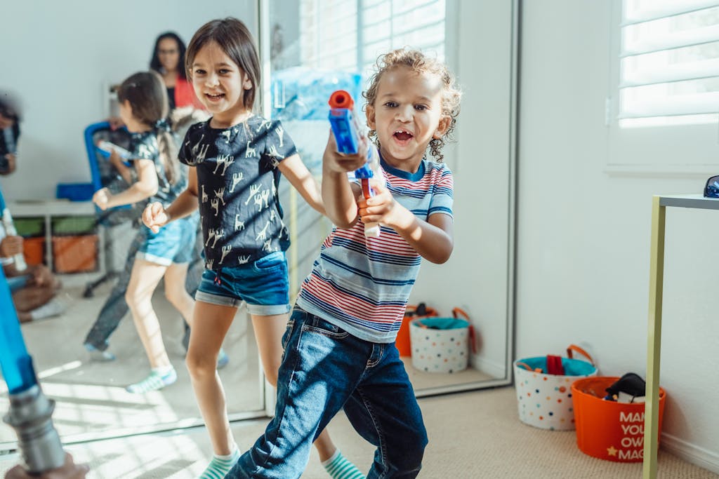 Children having fun playing with toy guns indoors, reflecting joy and energy.